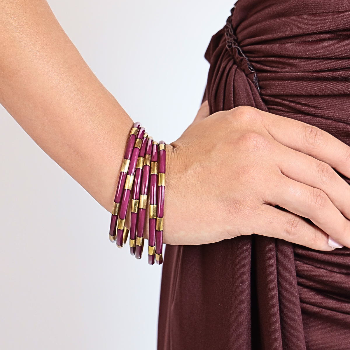 a person wearing a purple and gold bracelet