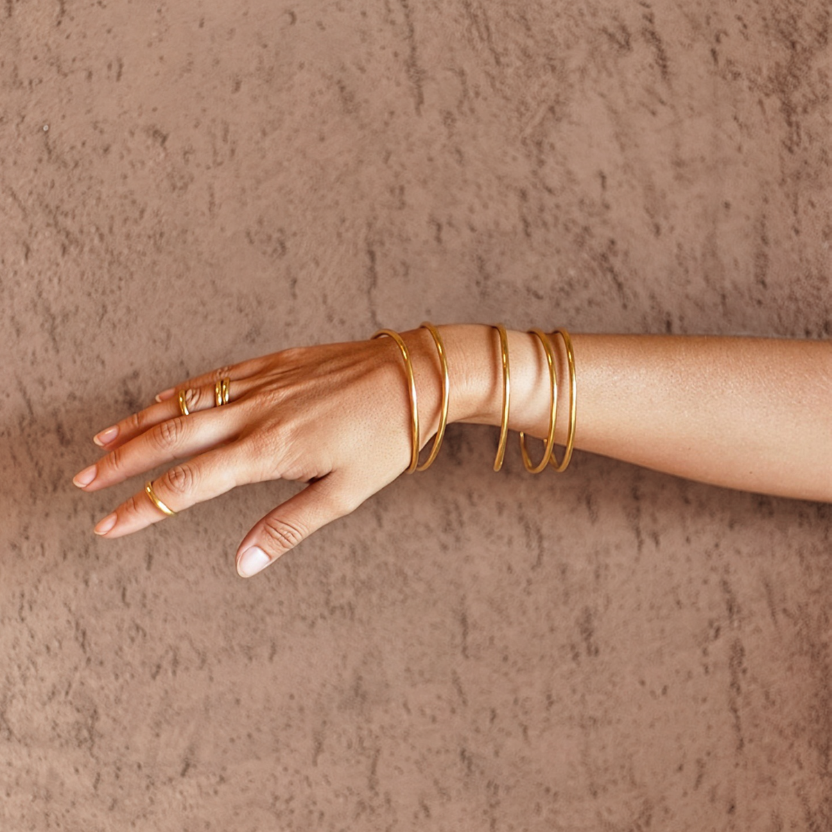 a hand with gold bracelets