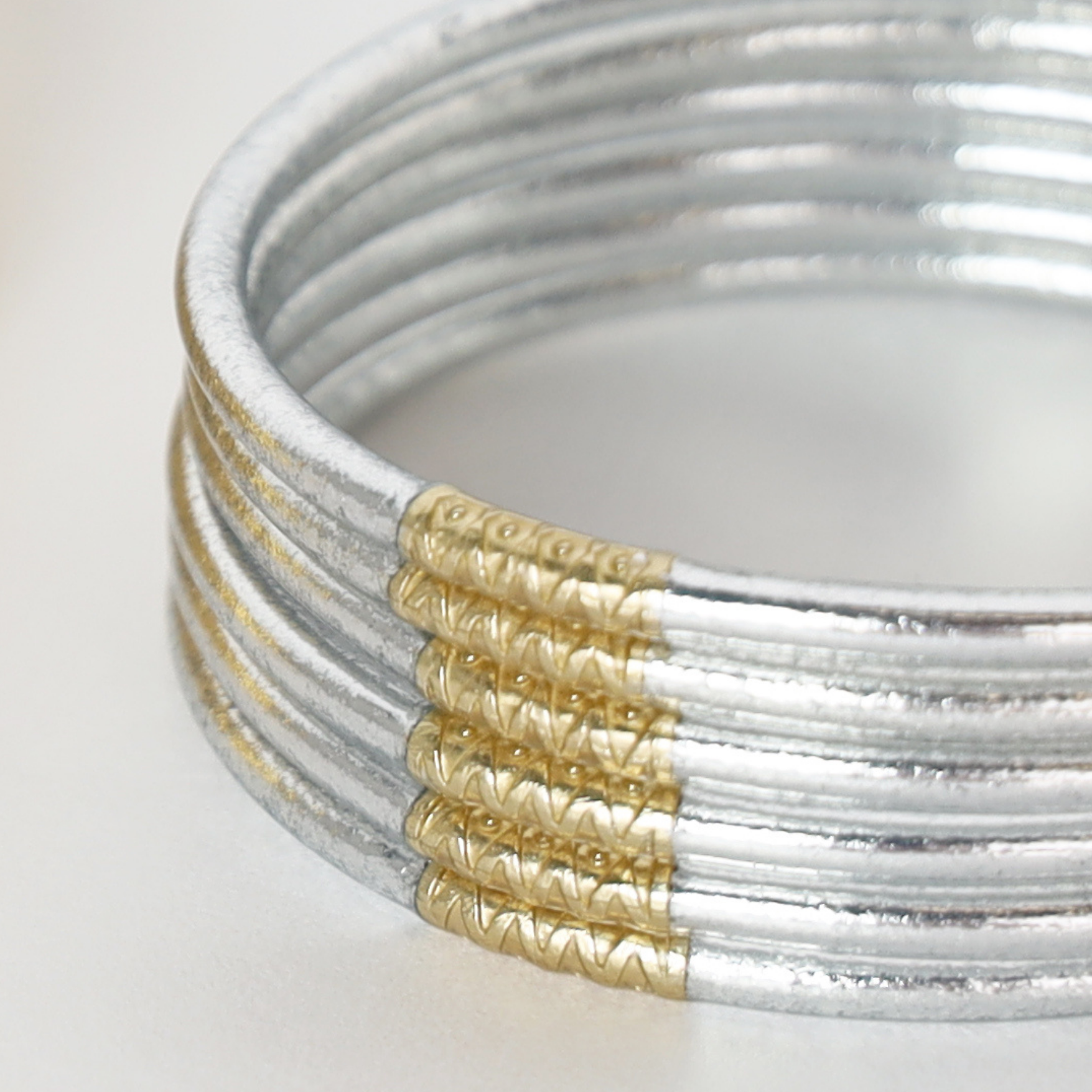 a stack of silver and gold bracelets