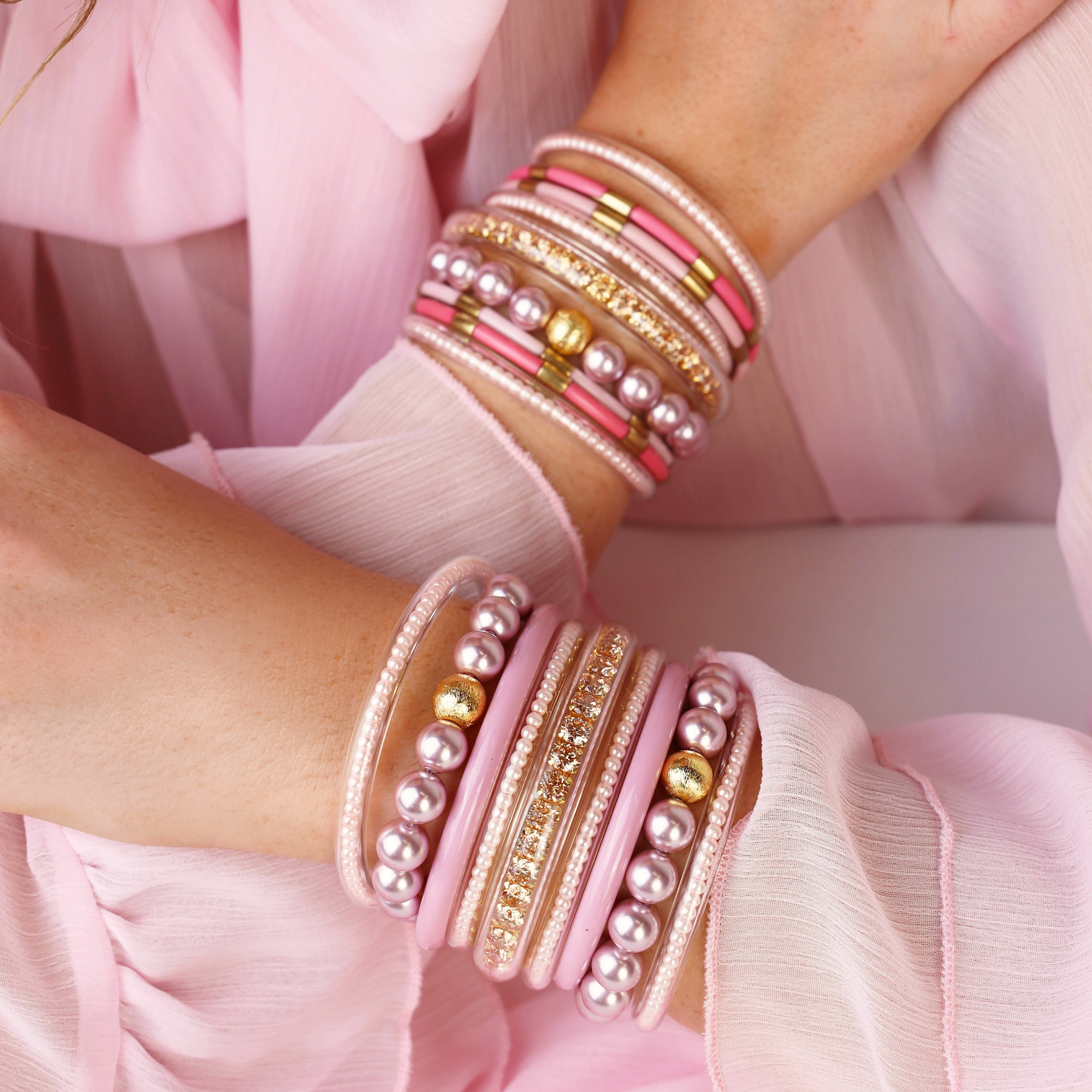 a close up of a woman's hands wearing bracelets