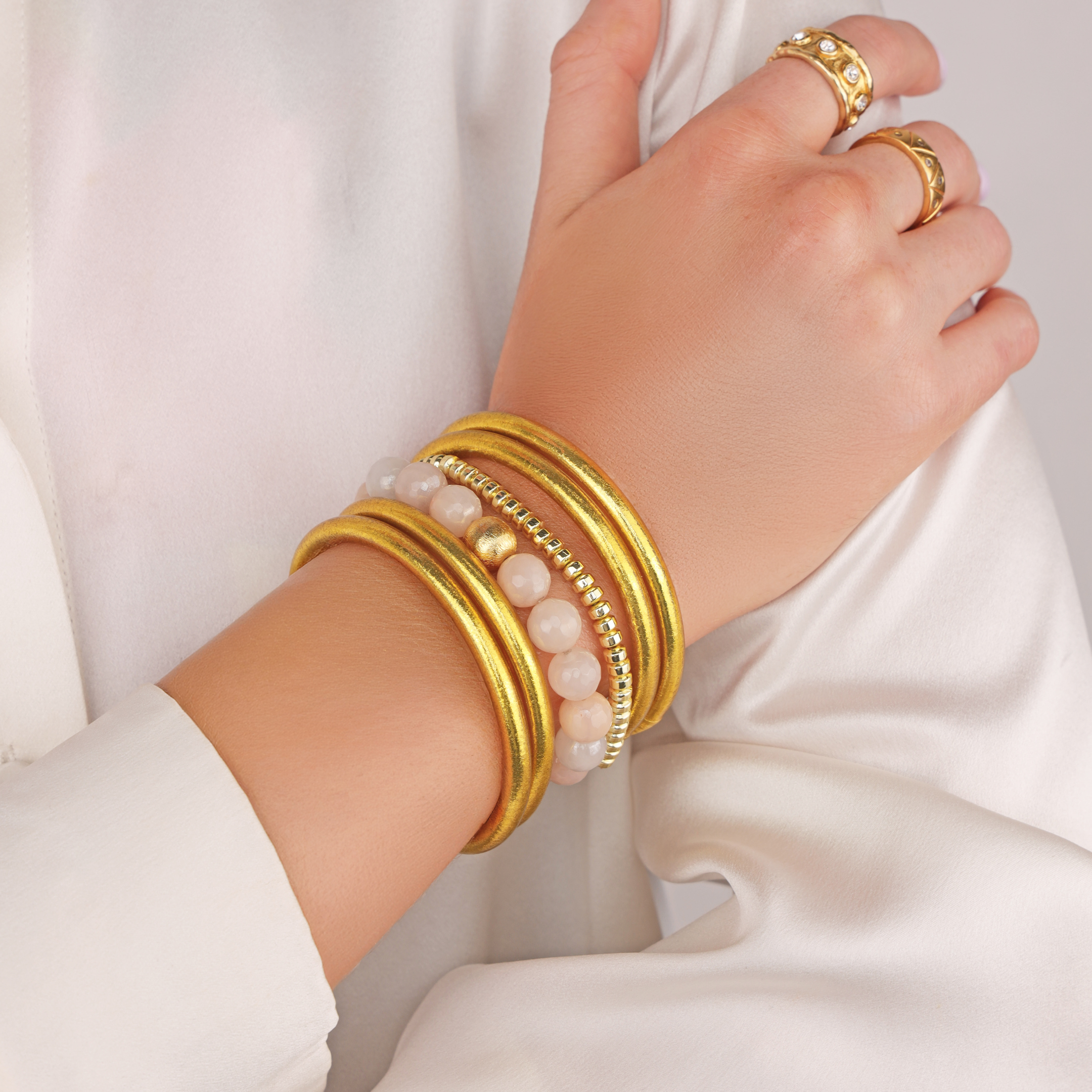 a person wearing gold bracelets