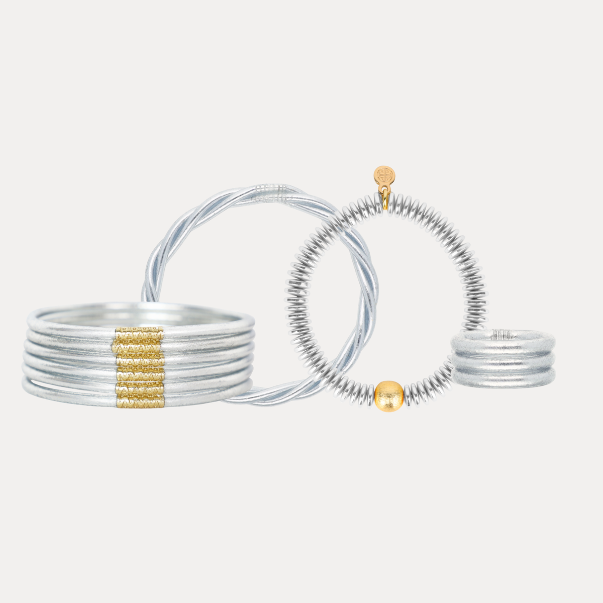 A set of silver-toned bangles and rings displayed on a light gray background.