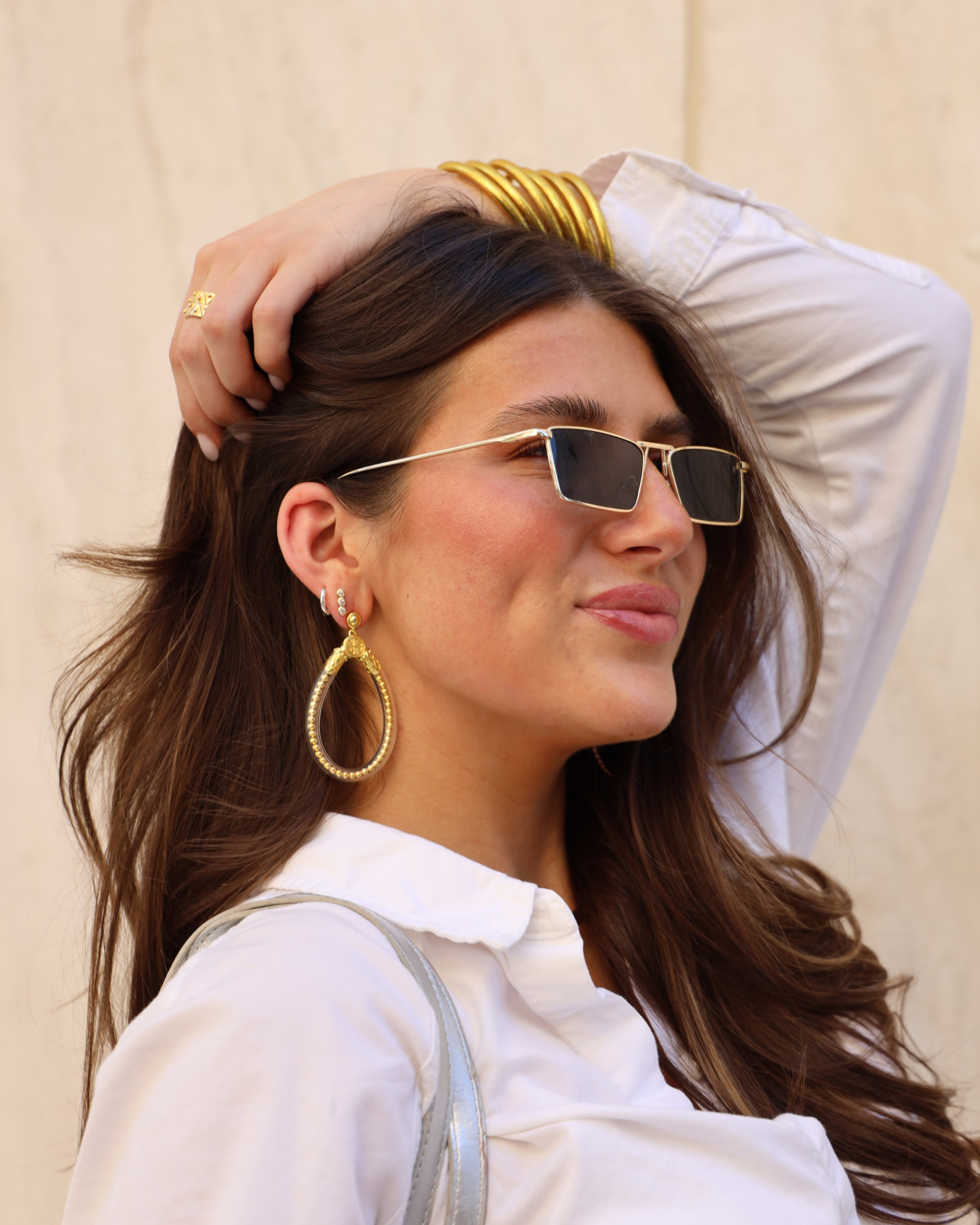 a woman wearing sunglasses and a white shirt