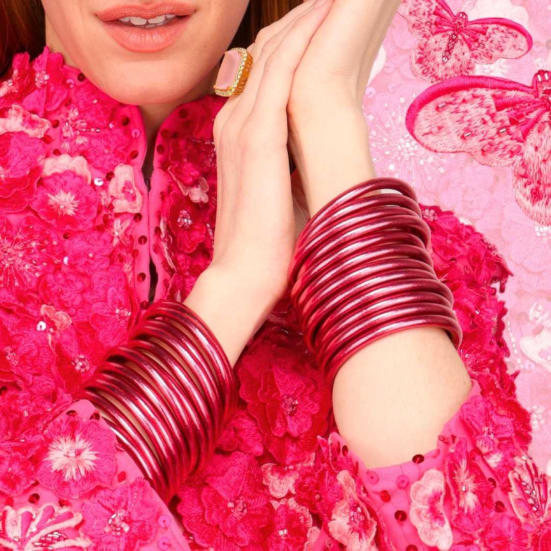 Close-up of a person wearing pink jewelry against a pink floral background