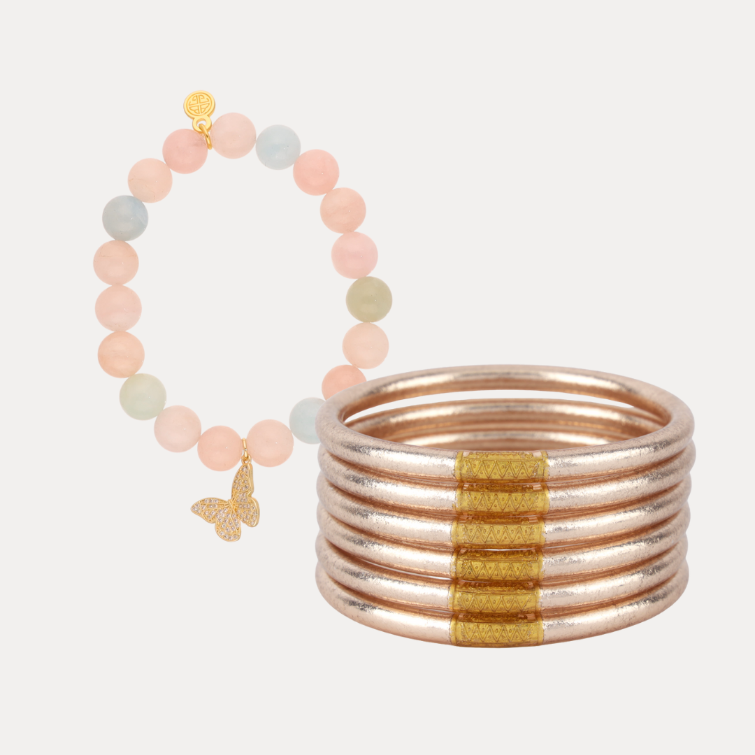 a stack of bracelets with a butterfly pendant