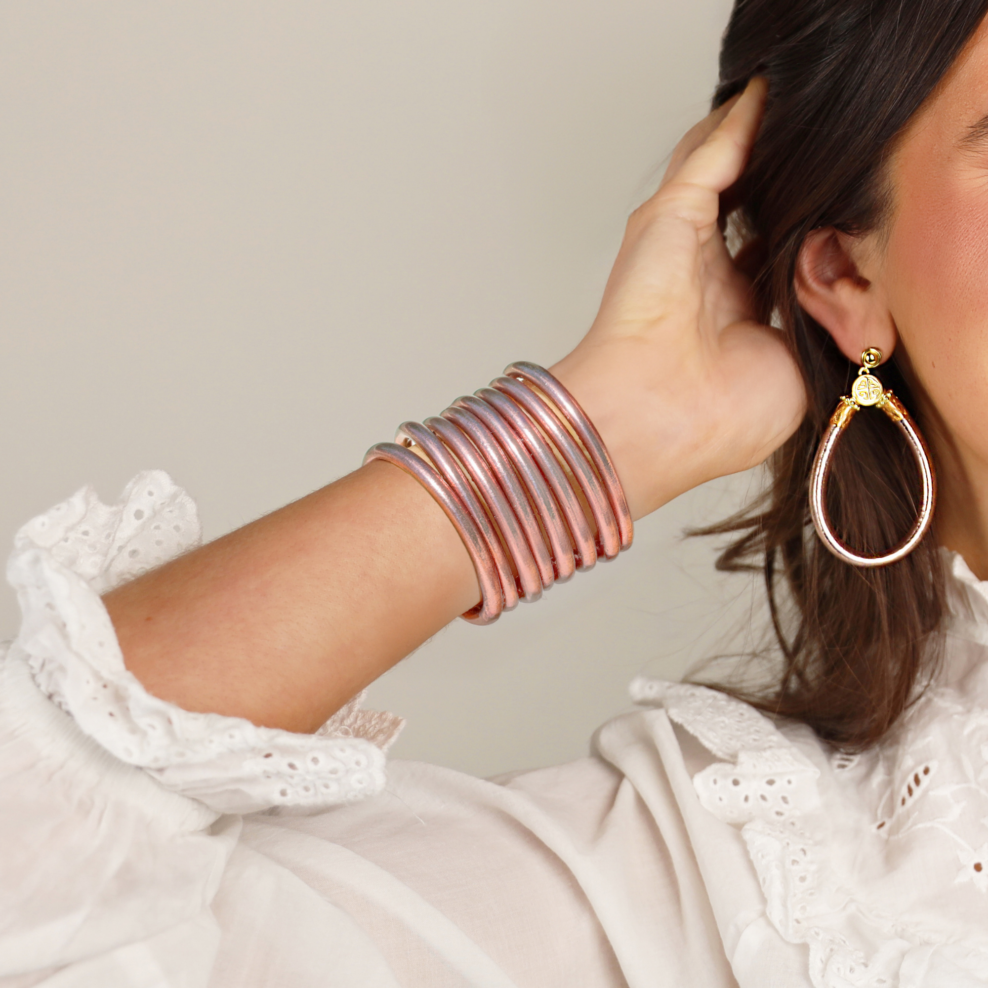a woman wearing a white blouse and bracelets