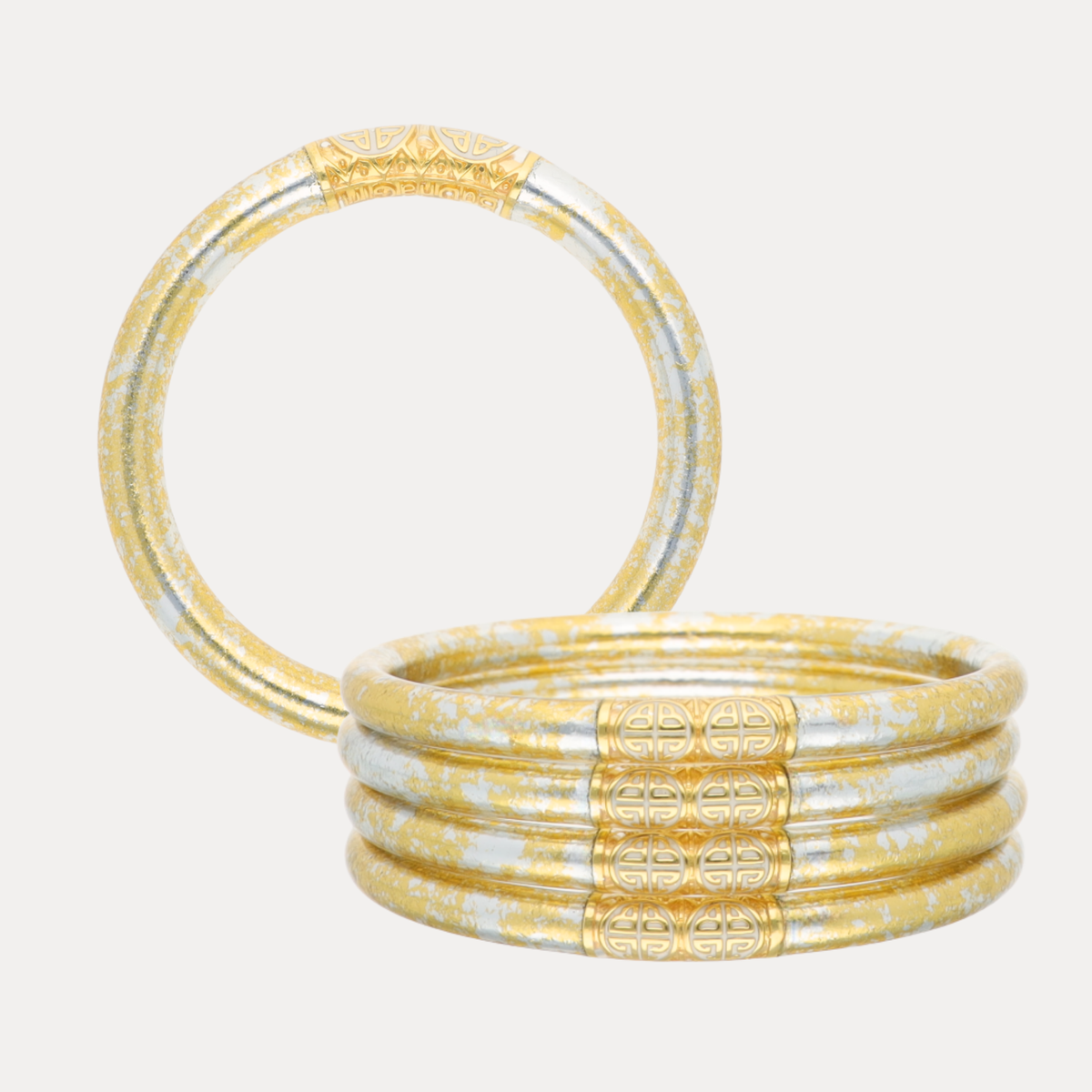 BuDhaGirl bangle bracelets for women in clear flexible tubing with warm gold and cool silver details shown as a stacked set with one bracelet standing upright