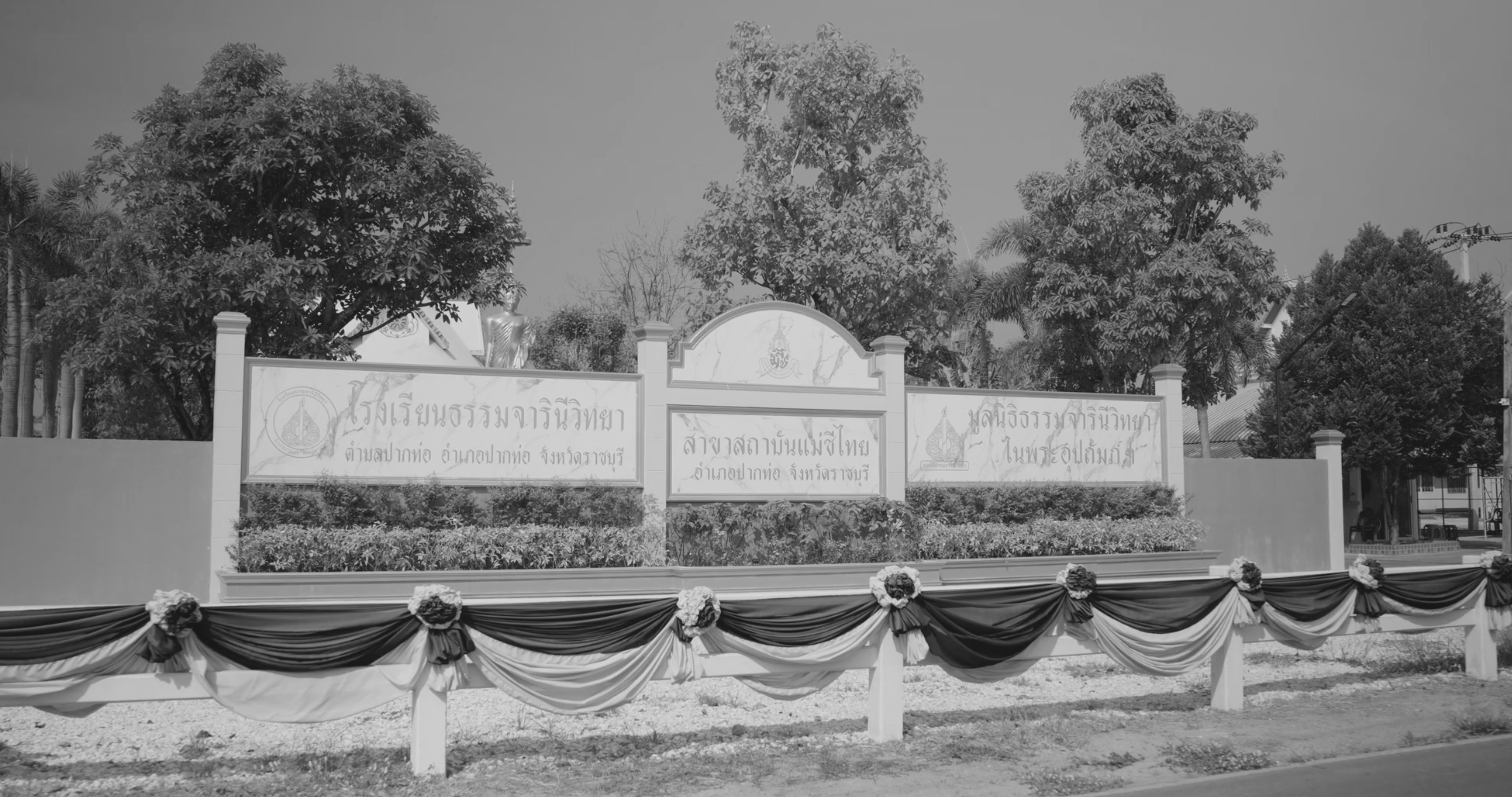a sign with a banner and flowers