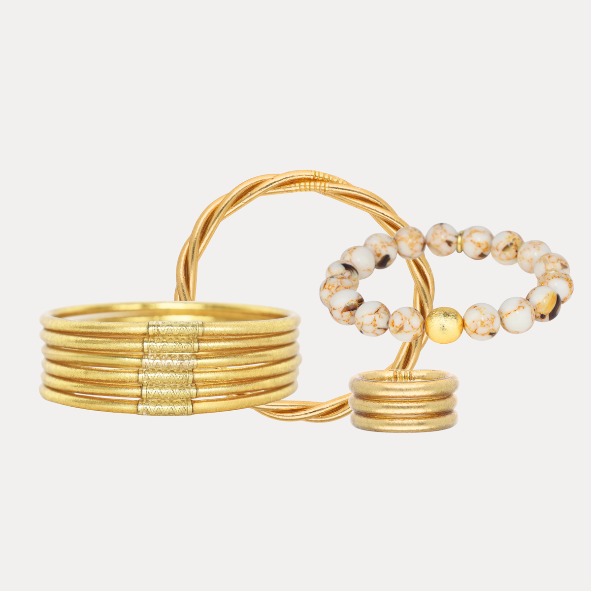 A set of gold-toned jewelry pieces on a light gray background.