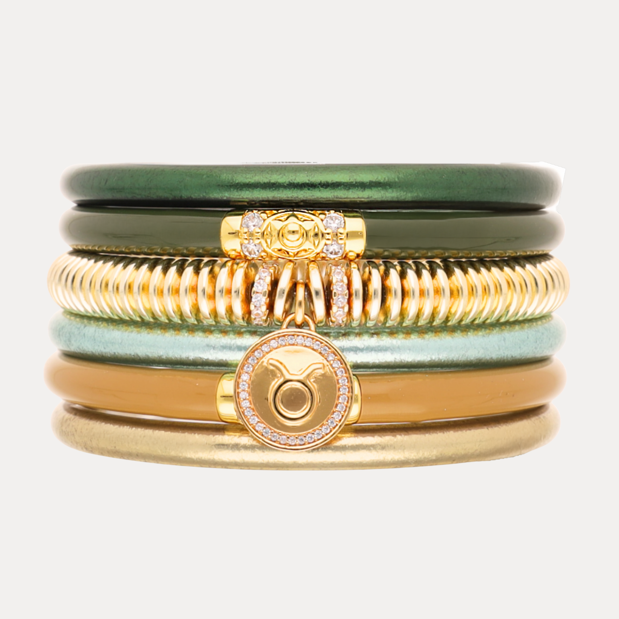 a stack of bracelets with gold and green bracelets