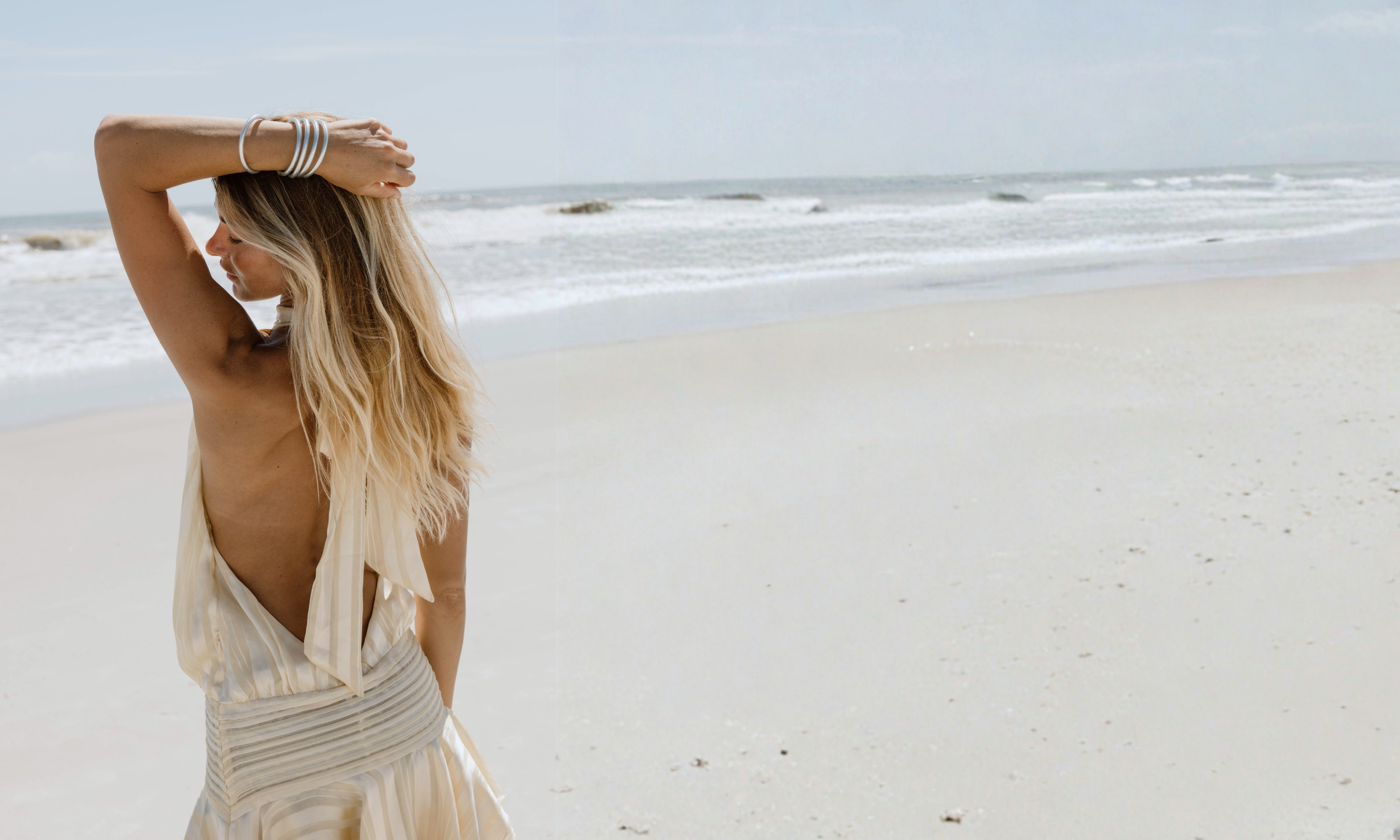 a woman in a white dress on a beach